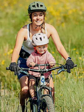 Mère et son enfant sur un vélo électrique équippé du système shotgun